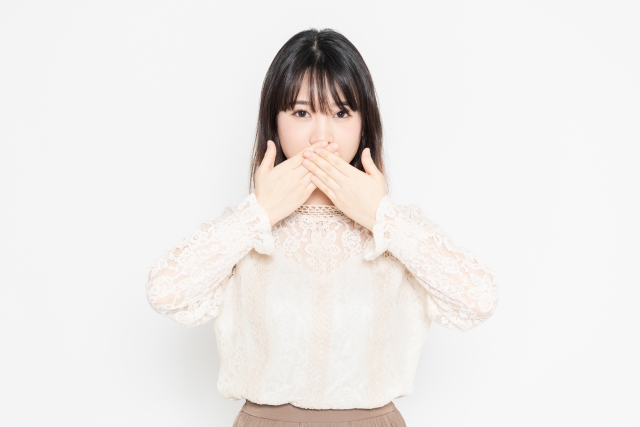 口を抑える女性